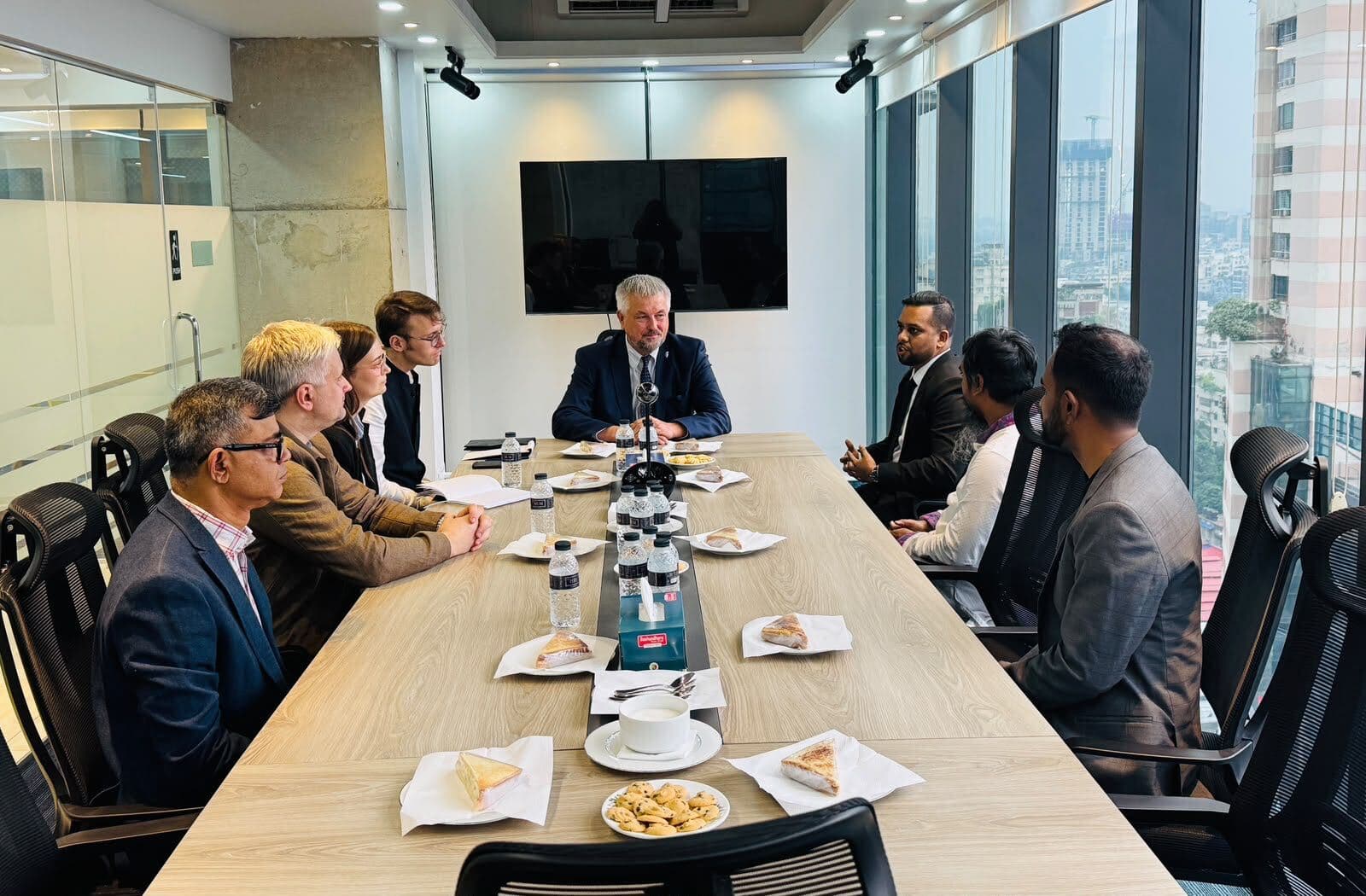 Members of the delegation and Eskimi colleagues in discussion around a boardroom table.